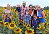 Family picture in field of sunflowers.