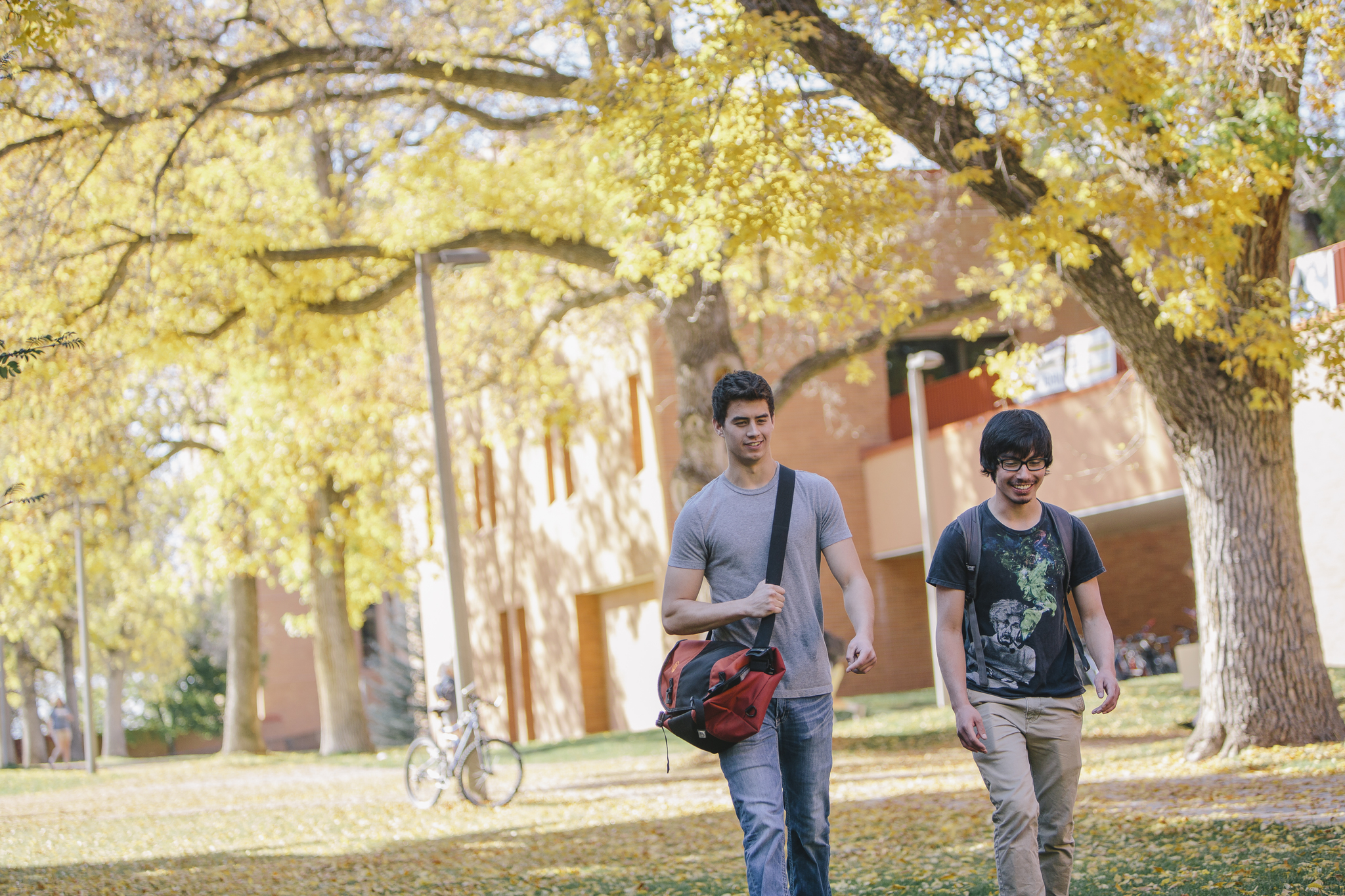 2 students enjoying a fall day outside Wilson Hall.